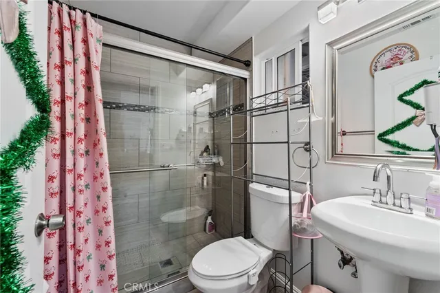 a view of a hallway with wooden floor and a bathroom