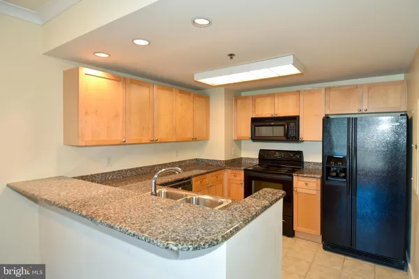 a kitchen with granite countertop a sink a counter top space appliances and cabinets