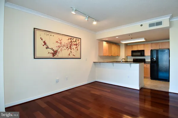 a view of a kitchen with wooden floor and a refrigerator