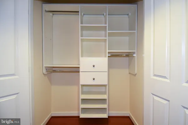 a view of walk in closet with empty racks