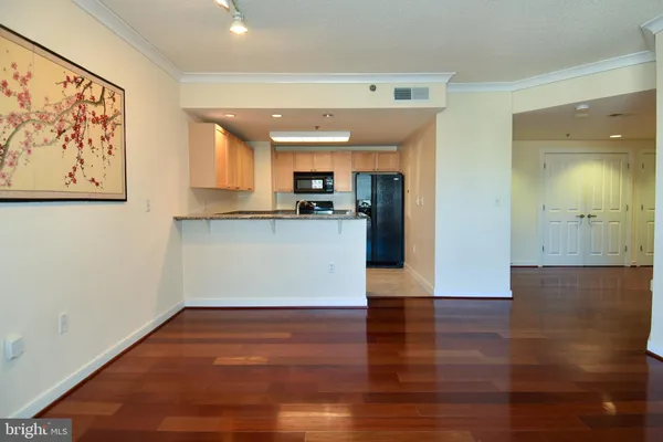 a view of a kitchen with wooden floor and a window
