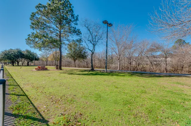 a view of yard with swimming pool and trees in the background