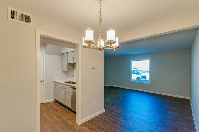 a view of a kitchen and an empty room