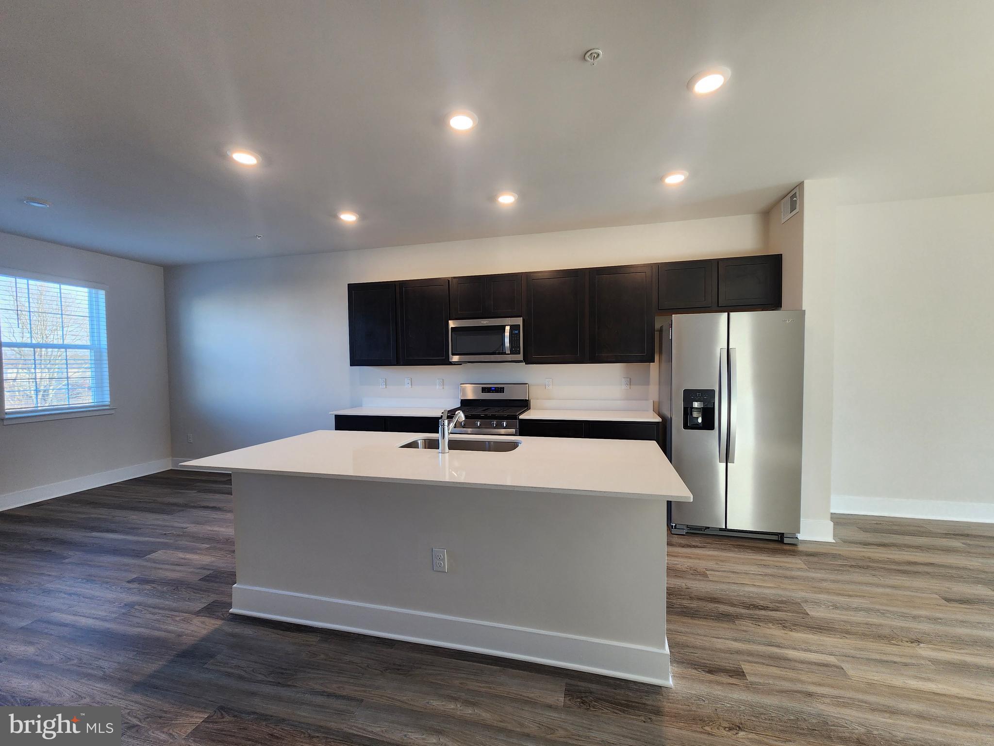 215 Joppa Farm Road Joppa, MD 21085 - Photo 7 of 19 a view of kitchen with stainless steel appliances wooden floor and large window