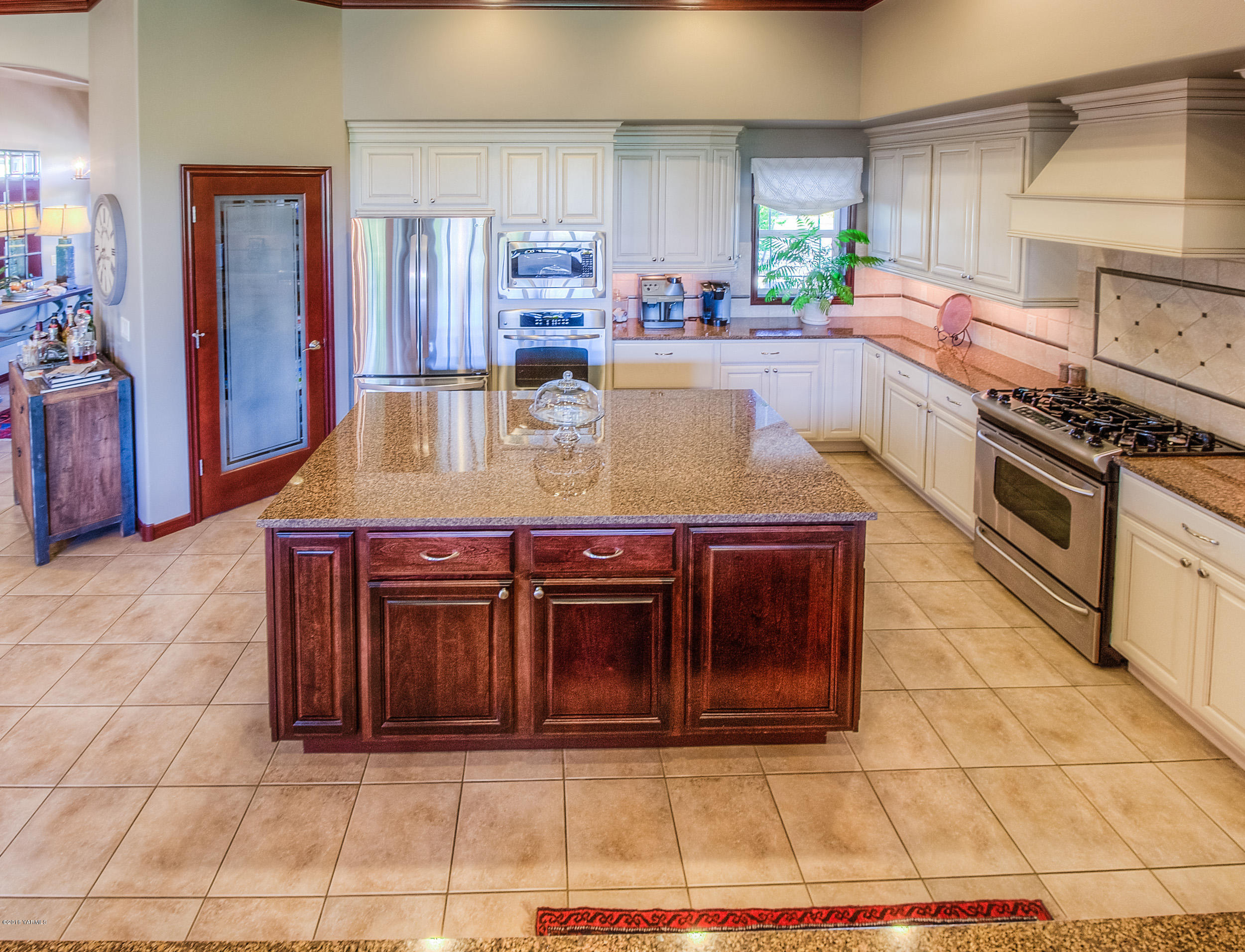 8970 Coolidge Road Yakima, WA 98903 - Photo 34 of 60 a kitchen with kitchen island granite countertop a stove and cabinets