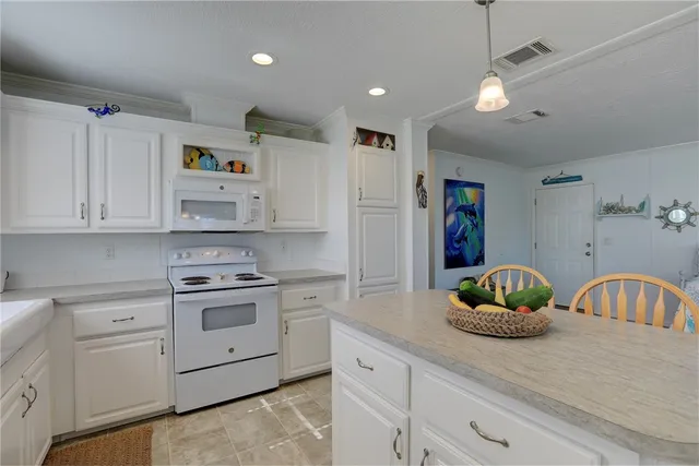 a kitchen with white cabinets and white appliances