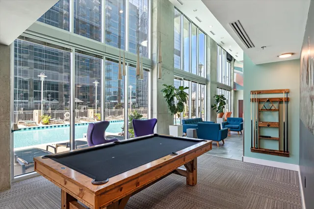 a living room with furniture a flat screen tv and kitchen view
