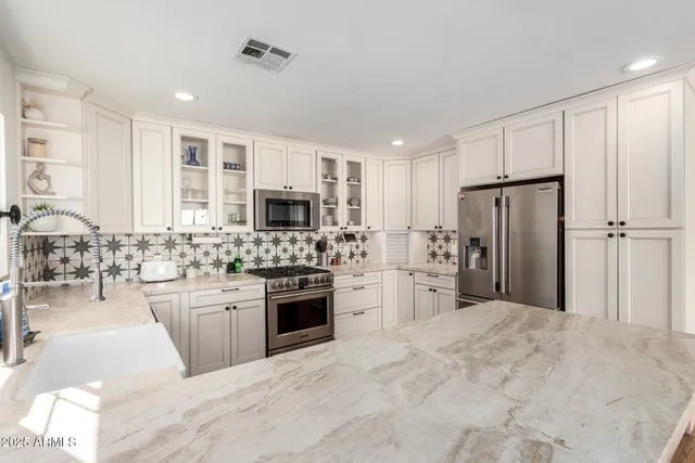 a large kitchen with cabinets stainless steel appliances and a window