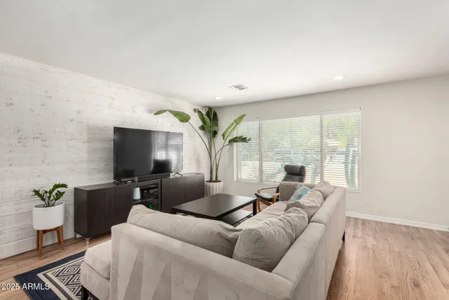 a living room with furniture a large window and a flat screen tv