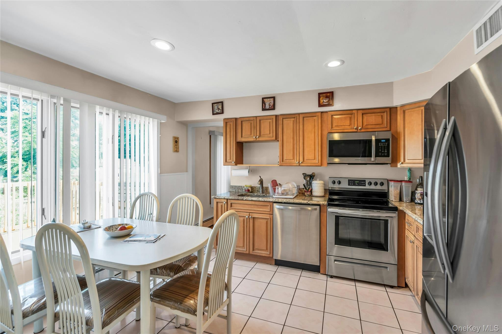 639 Townline Road Hauppauge, NY 11788 - Photo 13 of 28 a kitchen with stainless steel appliances granite countertop a stove a sink dishwasher a dining table and chairs