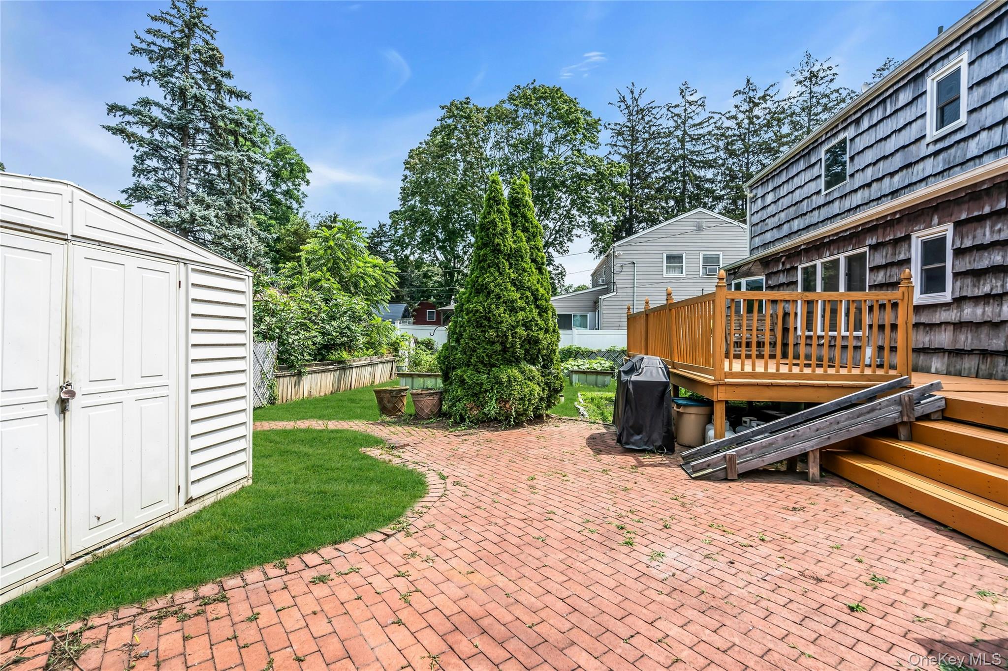639 Townline Road Hauppauge, NY 11788 - Photo 4 of 28 a view of a backyard with a small deck and a garden