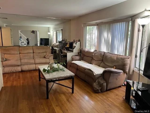 a living room with furniture and a wooden floor