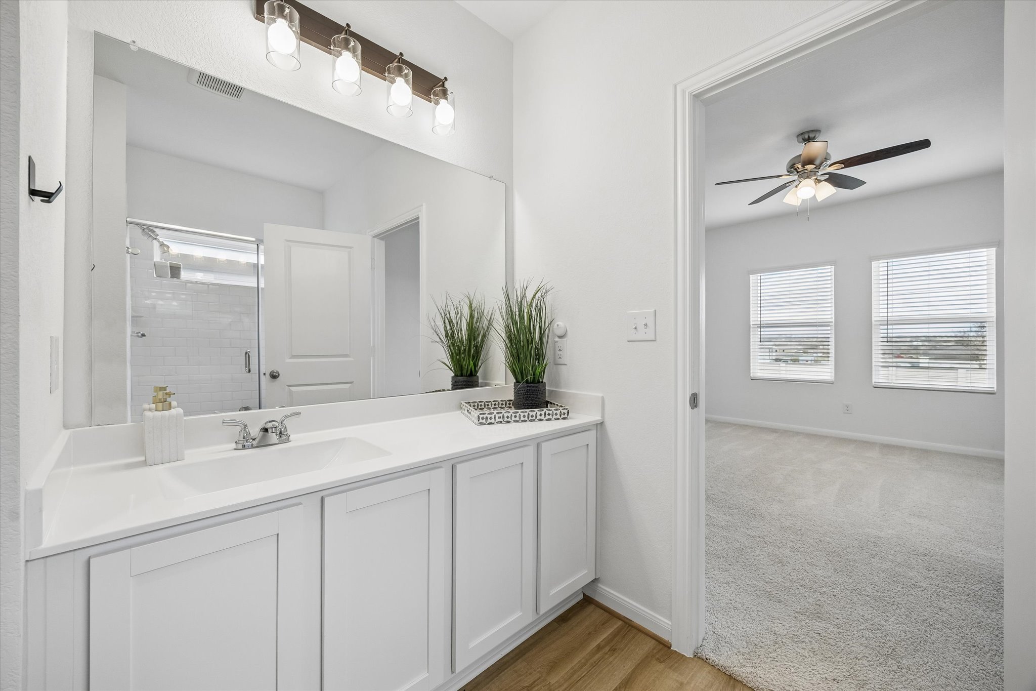 157 LT Rusty Drive Jarrell, TX 76537 - Photo 17 of 39 Full bathroom with vanity, light wood-style flooring, ceiling fan, a shower stall, and light carpet