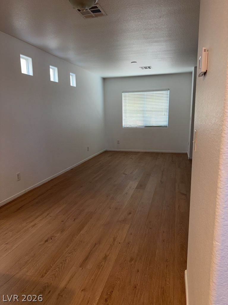4790 Pinon Pointe Road Las Vegas, NV 89115 - Photo 5 of 16 Natural light filters into this spacious area, highlighting the warm wood flooring.