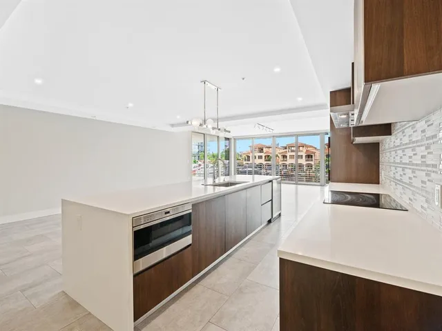 a open kitchen with stainless steel appliances kitchen island granite countertop a sink and white cabinets