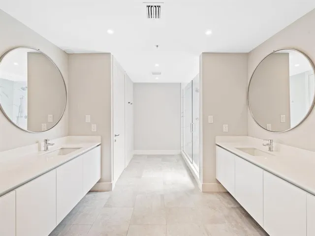 a spacious bathroom with a double vanity sink mirror and bathtub
