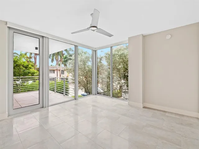 an empty room with fan and windows