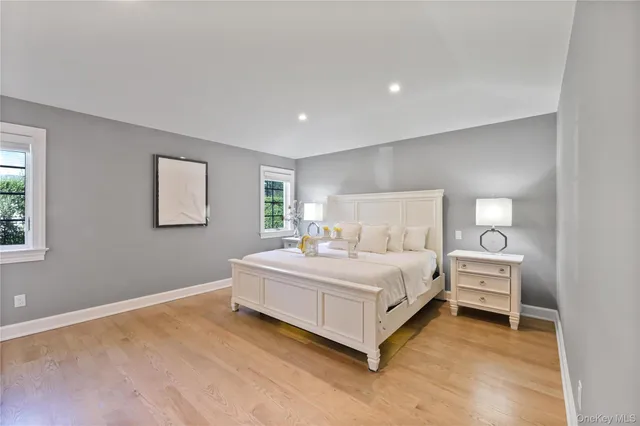 a white bed sitting in a bedroom next to a window