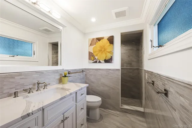 a bathroom with a granite countertop sink toilet and shower