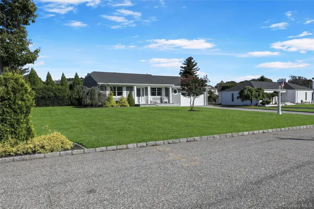 a view of a house with a big yard and large trees
