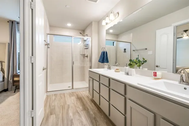 a bathroom with a double vanity sink mirror and shower