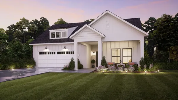 a front view of house with yard and trees in the background