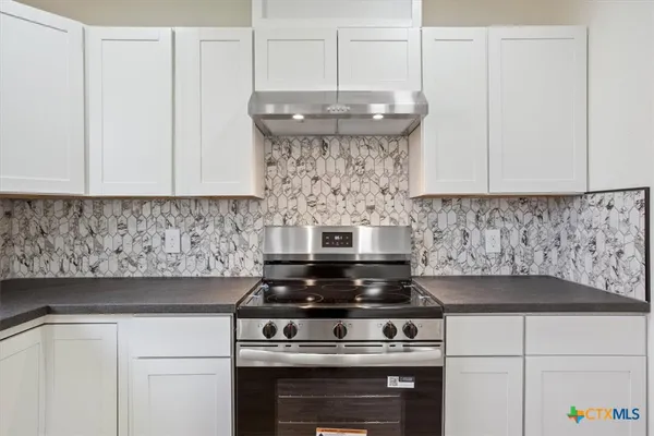a stove top oven sitting inside of a kitchen
