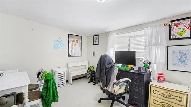a view of a workspace with furniture and a window