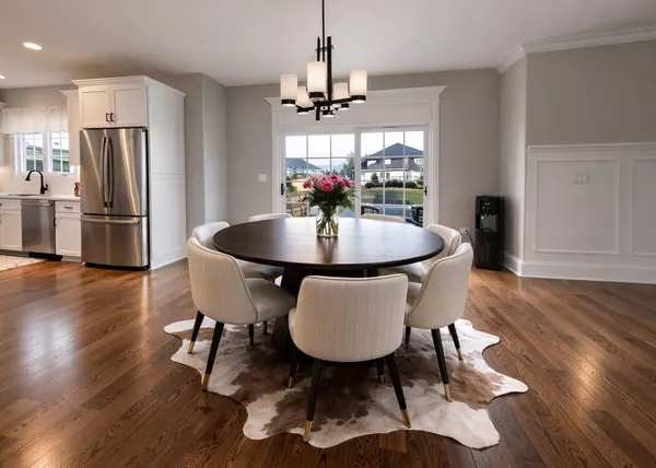 a dining room with furniture a chandelier and wooden floor