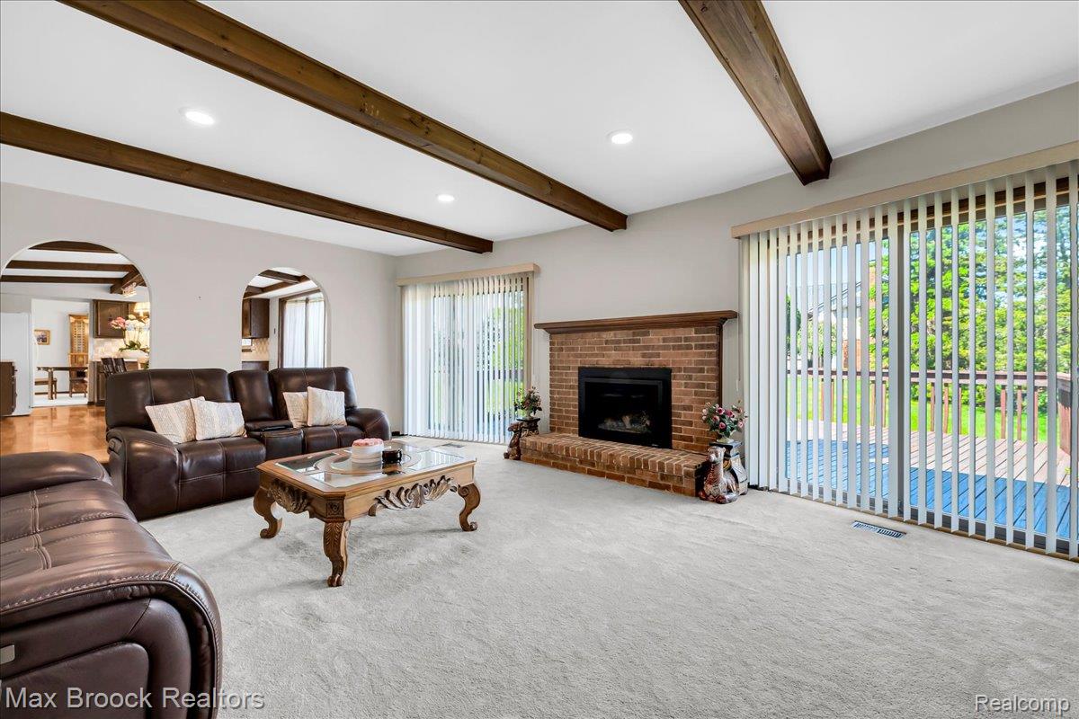 217 Stonetree Circle Rochester, MI 48309 - Photo 21 of 44 Spacious living area featuring exposed wood ceiling beams, recessed lighting, and light-toned carpeting