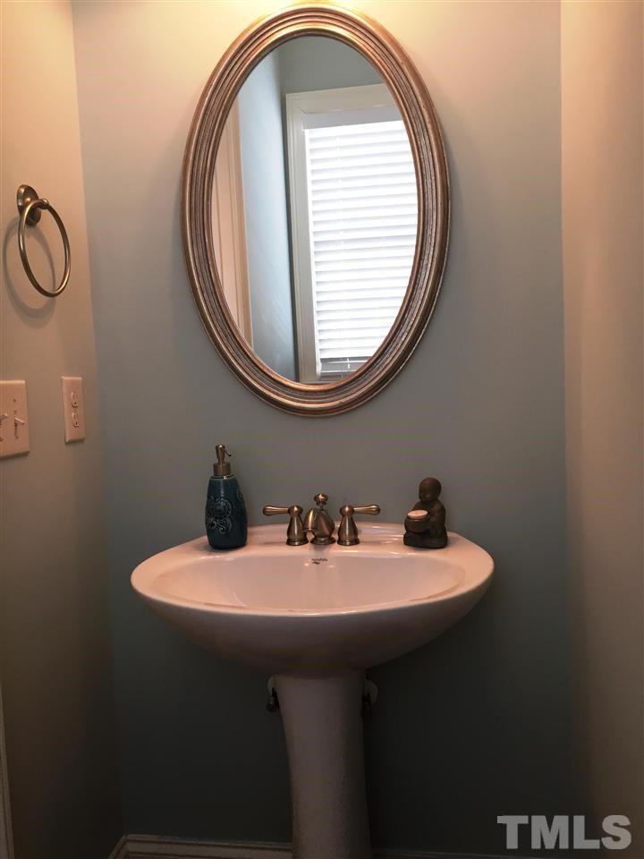 1307 Ileagnes Road Raleigh, NC 27603 - Photo 24 of 24 Main floor powder room has hardwood floors and a pedestal sink. Powder Room