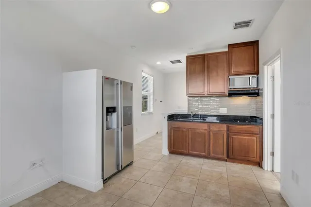 a kitchen with stainless steel appliances granite countertop a refrigerator and a stove top oven