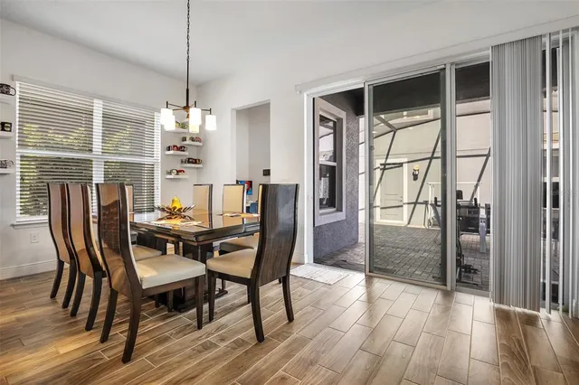 a dining room with furniture a chandelier and wooden floor