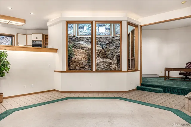 a view of an empty room with glass door and windows