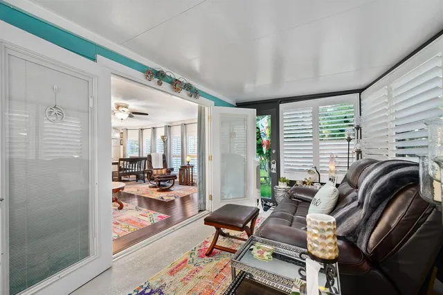 a view of a livingroom with lounge chair and a large window