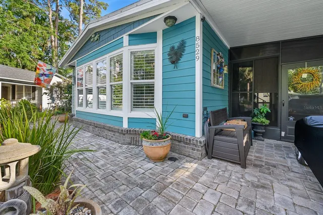 a view of a chair and tables in the patio in front of house