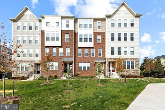 a front view of a residential apartment building with a yard