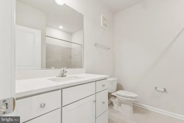 a bathroom with a toilet sink vanity and mirror
