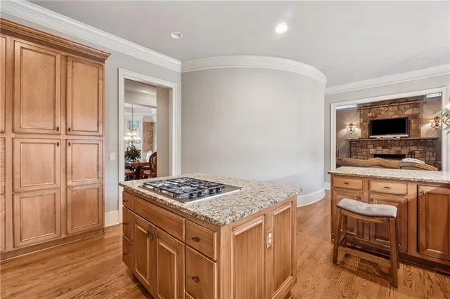 a kitchen that has a kitchen island wooden cabinets and stainless steel appliances