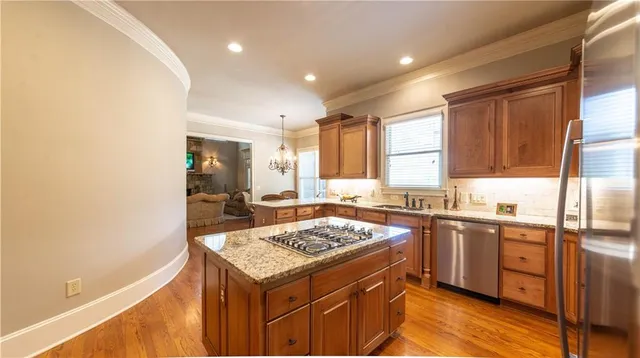 a kitchen with stainless steel appliances granite countertop a sink stove and refrigerator
