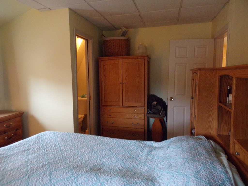 74 James Street Acushnet, MA 02743 - Photo 24 of 41 a bedroom with a bed and wooden cabinets