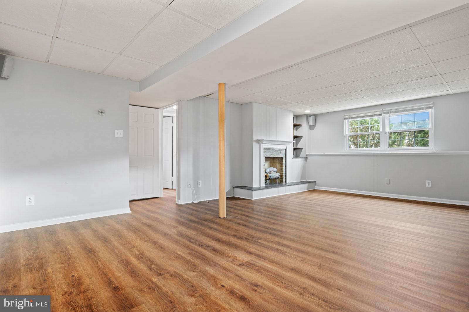 516 Nollmeyer Road Baltimore, MD 21220 - Photo 45 of 67 an empty room with wooden floor fireplace and windows