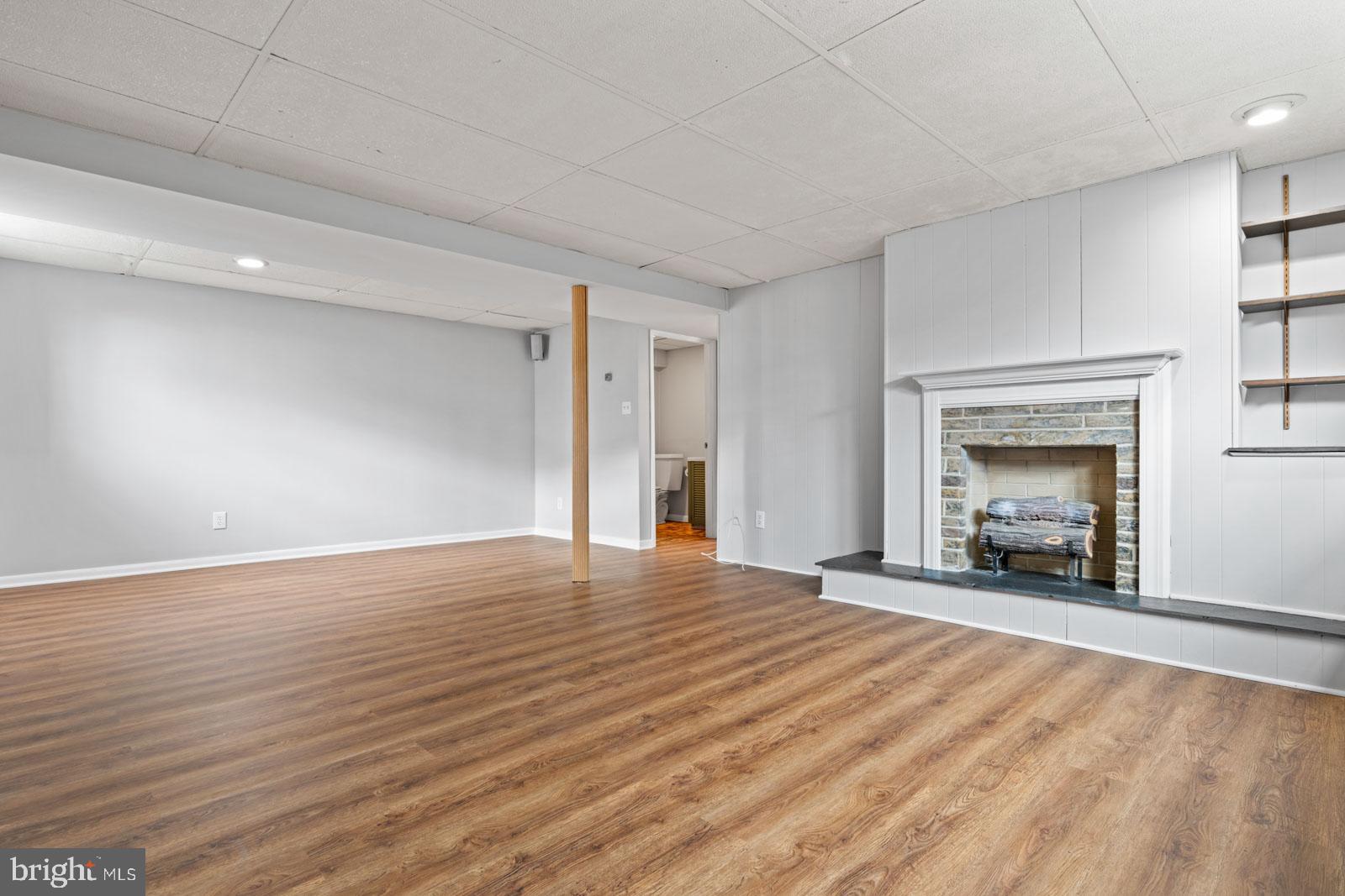516 Nollmeyer Road Baltimore, MD 21220 - Photo 46 of 67 an empty room with wooden floor fireplace and windows