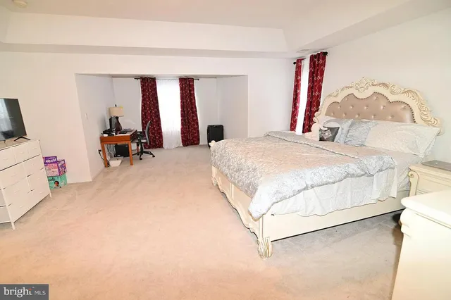 a bedroom with a bed a couch and dresser