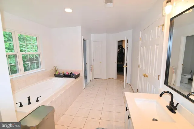 a bathroom with a tub sink and mirror