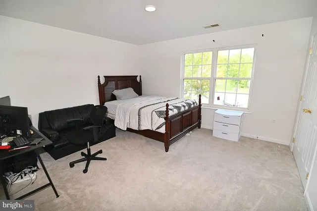 a spacious bedroom with a bed and a window