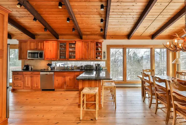 a view of a living room and kitchen floor to ceiling windows