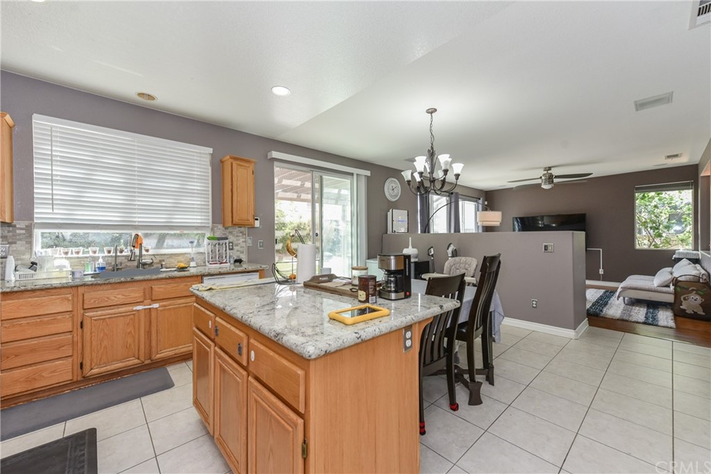 7637 Pinot Place Rancho Cucamonga, CA 91739 - Photo 12 of 39 a kitchen with a dining table chairs cabinets and stainless steel appliances