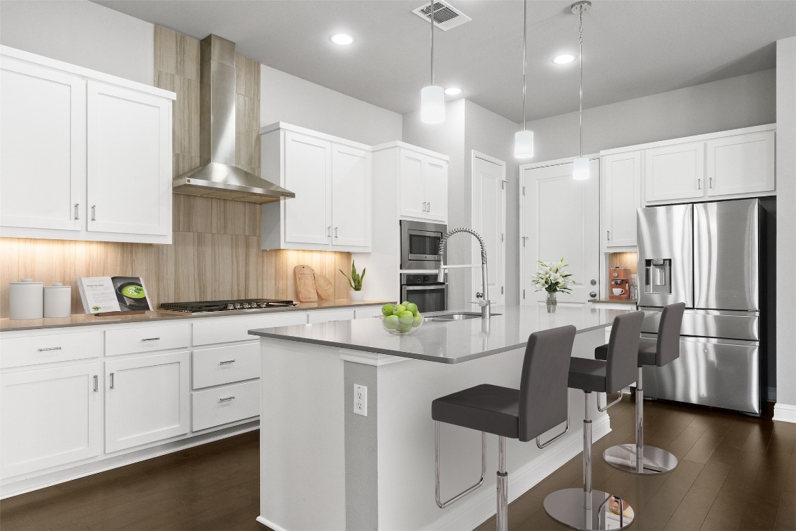 The kitchen stands as the centerpiece for culinary enthusiasts, featuring quartz countertops, a modern tile backsplash, and sleek white shaker-style cabinetry *Virtually staged photo