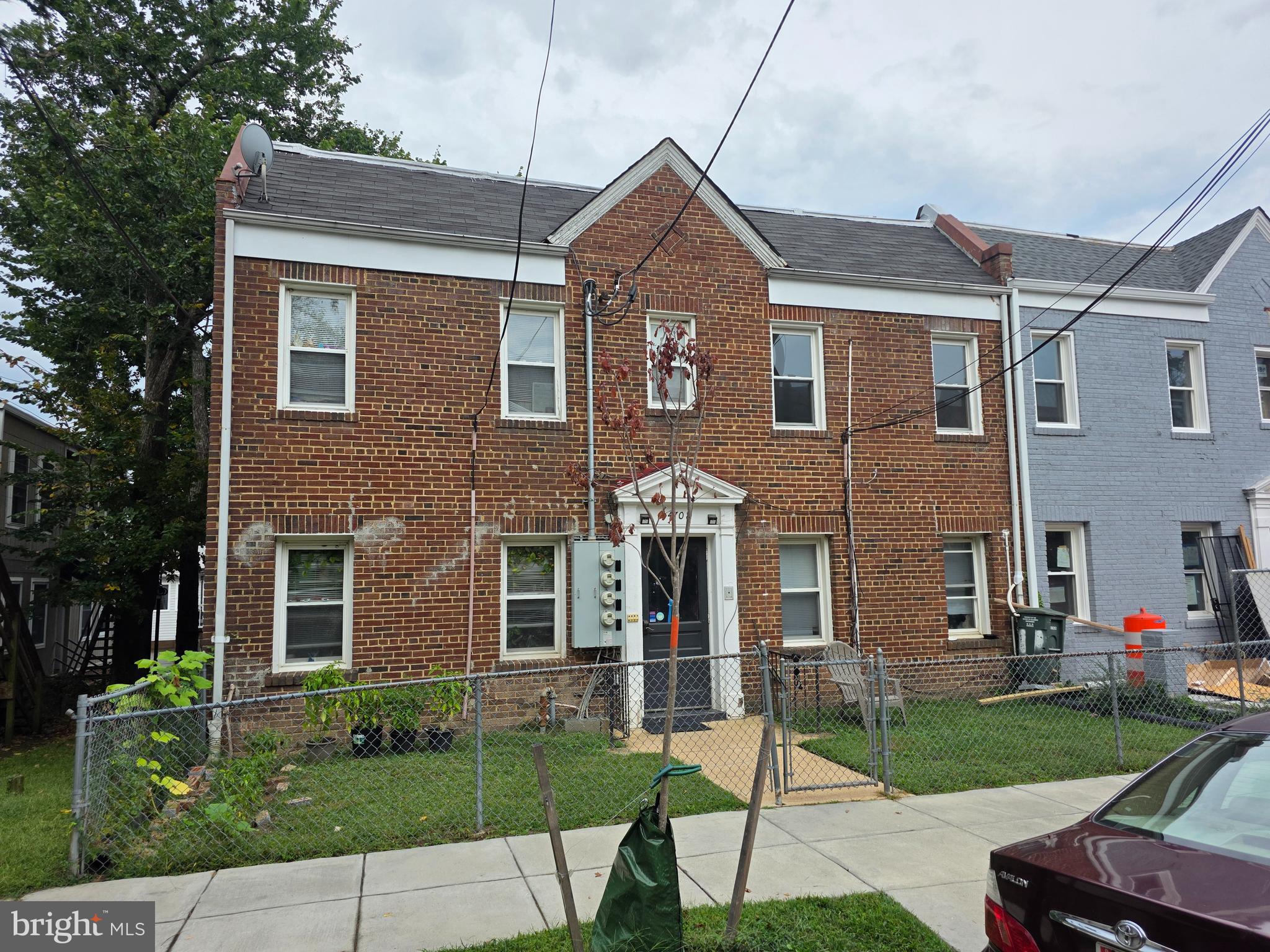 a view of a brick house with a yard and plants